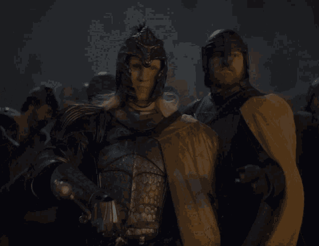 a man in armor holding a sword stands next to another man