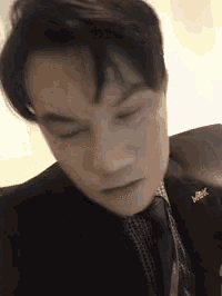 a man in a suit and tie is looking down .