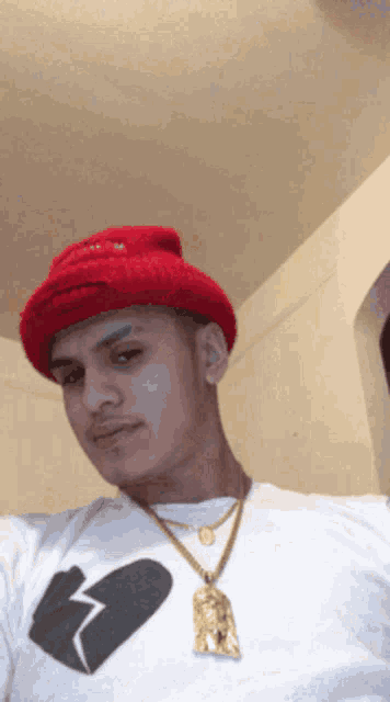 a man wearing a red hat and a white shirt with a broken heart