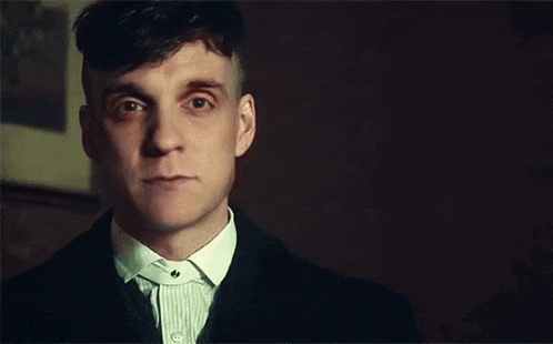 a close up of a man wearing a suit and tie looking at the camera .