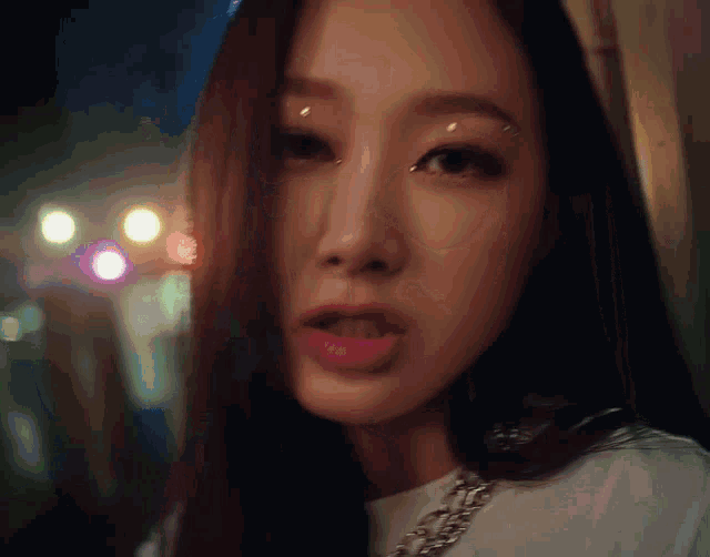 a close up of a woman 's face with a white shirt on