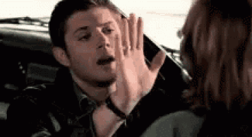 a woman is giving a man a high five in a car .