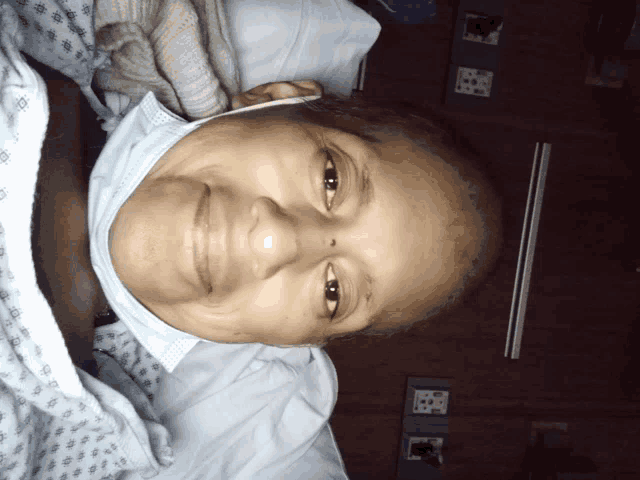 a woman in a hospital bed wearing a mask