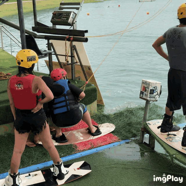 a person wearing a liquid force vest stands next to another person