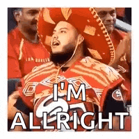 a man wearing a sombrero is sitting in a stadium with other people .