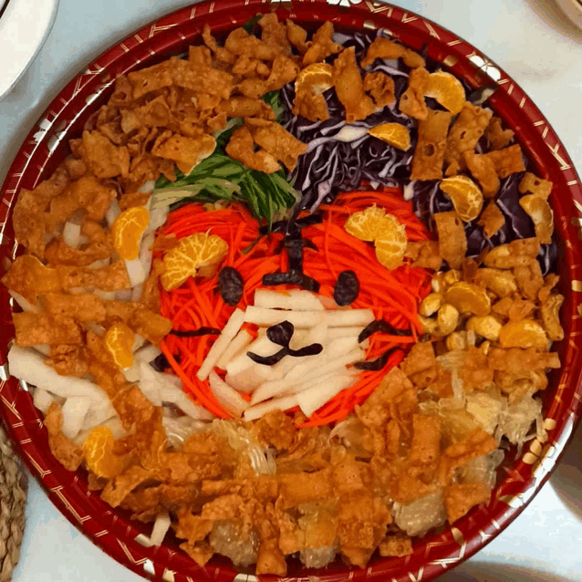 a plate of food with a face made out of carrots