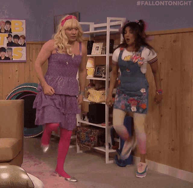 a man in a purple dress and a woman in a blue dress are dancing in a room with a sign that says bts