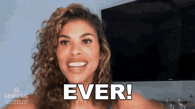 a woman is smiling and says ever in front of a television