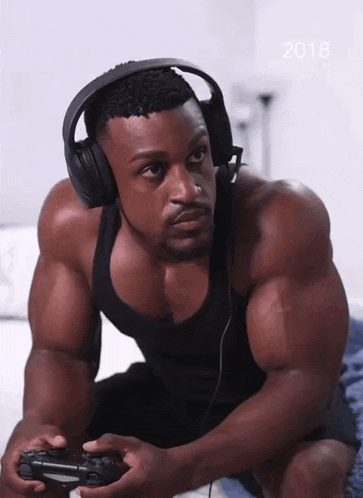 a man wearing headphones is playing a video game with the year 2018 behind him