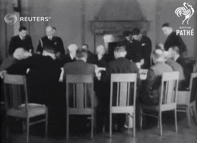 a group of men are sitting around a table with reuters written on the bottom right
