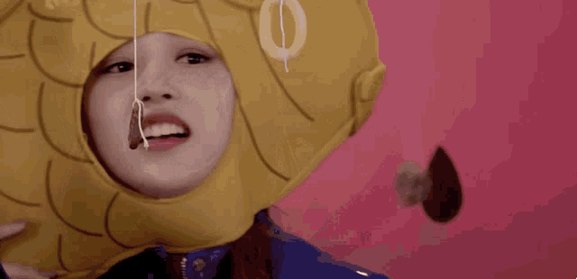 a woman is wearing a fish costume and eating a cookie .