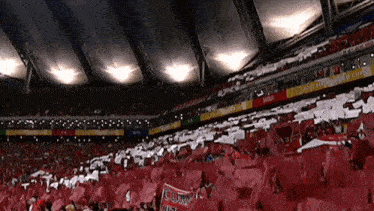 a crowd of people in a stadium with a sign that says " cum "