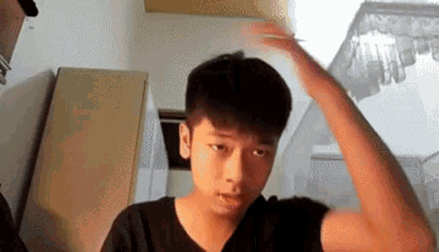 a young man is brushing his hair with a comb .