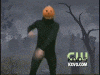 a person with a pumpkin on their head is standing in a cemetery ..