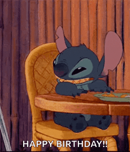 stitch from lilo and stitch is sitting at a table eating a sandwich .