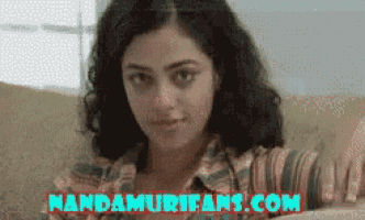 a woman sitting on a couch with mandamurifans.com written on the bottom right