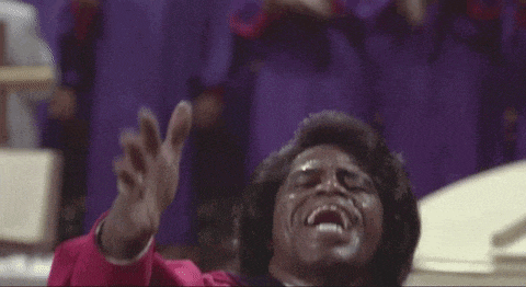 a man in a red robe is singing into a microphone