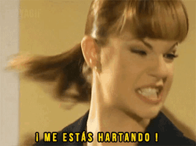 a close up of a woman 's face with the words i me estas hartando on the bottom