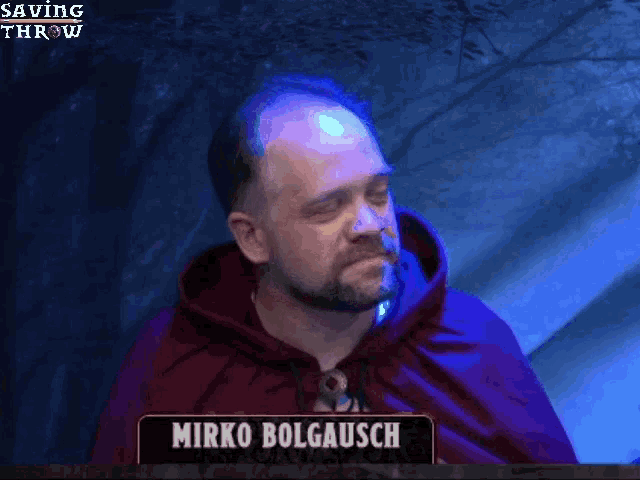 a man in a red cape is standing in front of a sign that says mirko bolgausch