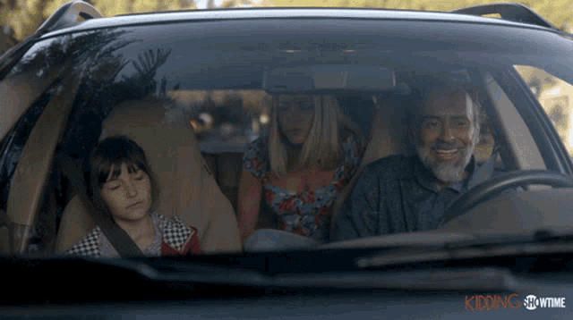 a family is sitting in a car with the word showtime on the bottom right
