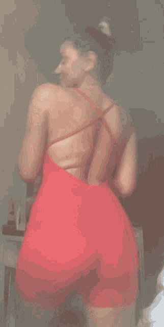 a woman in a red dress is standing in a room