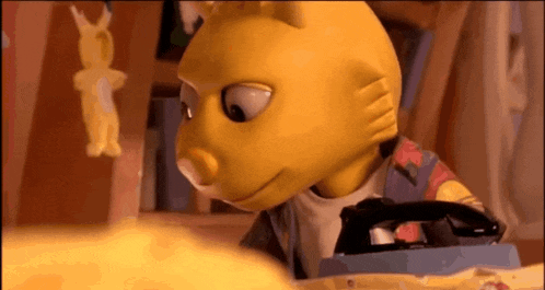 a yellow cartoon character is holding a black iron