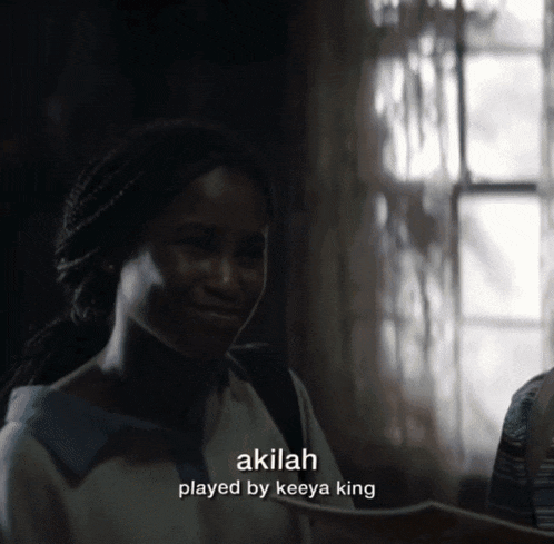 a woman in a dark room with the words akilah played by keeya king on the bottom