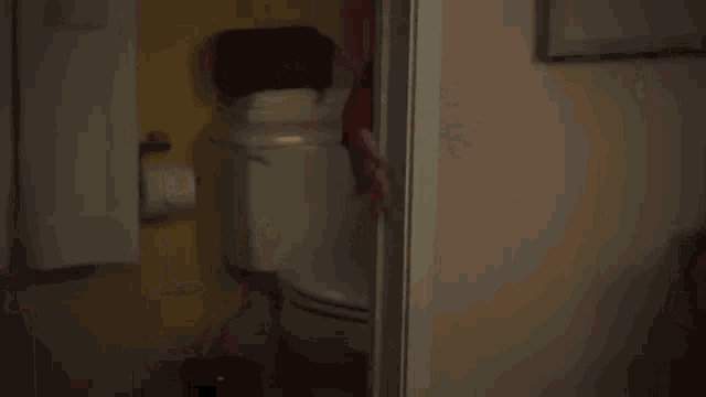 a woman in a red jacket and black skirt is dancing in a room