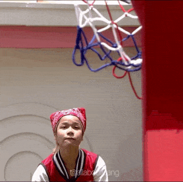 a girl wearing a red bandana stands in front of a basketball hoop