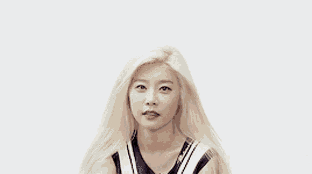 a woman with blonde hair is smiling and wearing a striped top