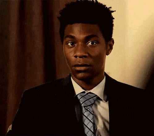 a man in a suit and tie is making a surprised face .