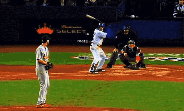 a baseball game is being played in front of a budweiser select advertisement