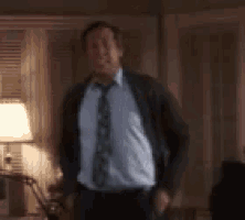 a man in a suit and tie is standing in a room with a lamp .