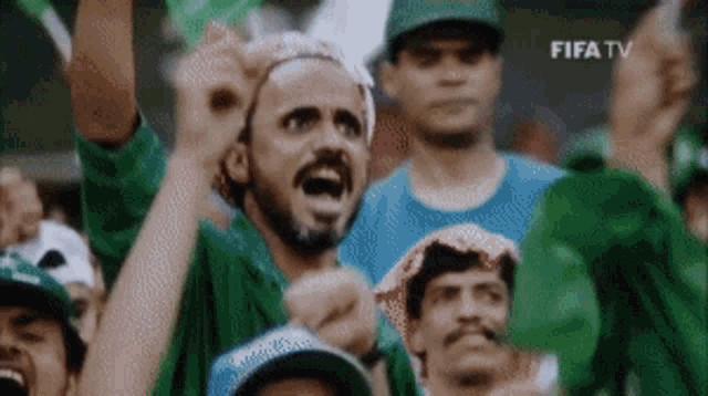 a group of people are watching a soccer game on a screen that says fifa tv