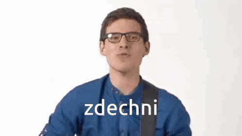 a man wearing glasses and a blue shirt is making a funny face while holding a guitar strap and says zdechni