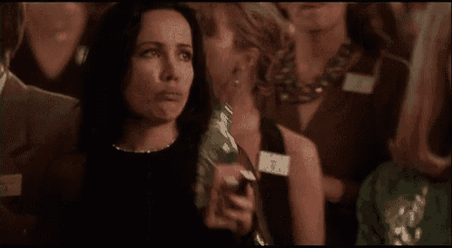 a woman is holding a bottle of water in a crowd of people .