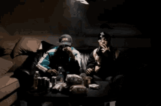 a man wearing a hat that says akira sits next to another man