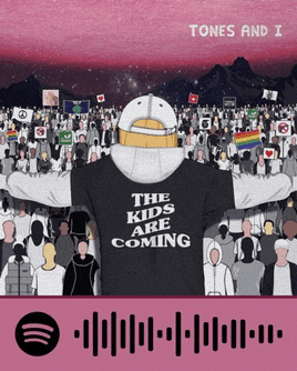 a man wearing a shirt that says the kids are coming stands in front of a crowd of people