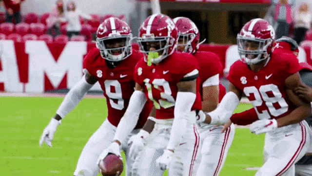 a group of football players wearing red uniforms with the number 29 on the back
