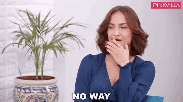 a woman in a blue dress covering her mouth with her hand and the words " no way " on the bottom