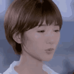 a close up of a woman 's face with short hair and bangs .