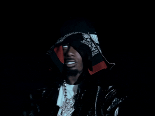 a man with a bandana on his head is wearing a hood