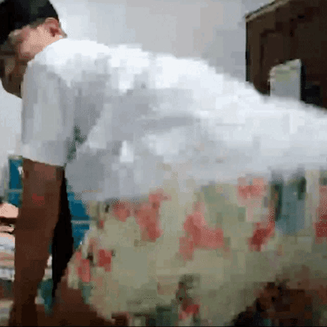 a man in a white shirt is doing push ups in a room