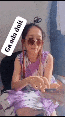 a girl wearing sunglasses and a purple dress is holding a pair of scissors ..