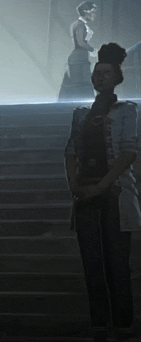 a woman in a military uniform is standing on a set of stairs in a dark room .