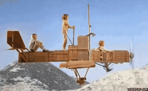 two children are riding a wooden airplane on top of a snow covered mountain ..