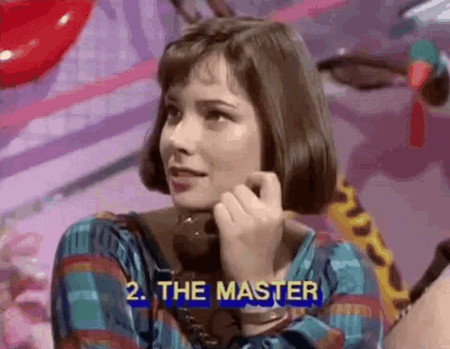 a woman is talking on a telephone with the words " the master " behind her