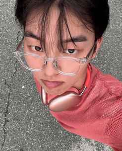 a man wearing glasses and headphones looks down at the camera