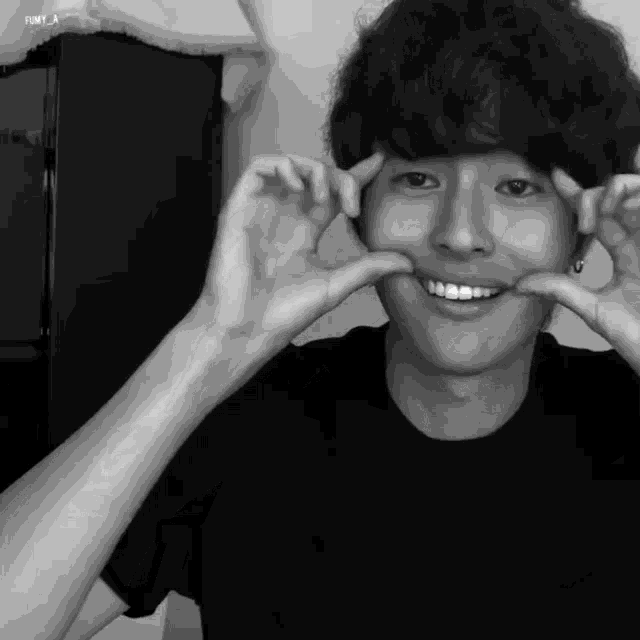 a black and white photo of a young man making a funny face