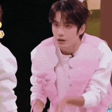a young man wearing a pink vest and gloves